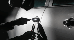 Autoeinbruch: Ein Mann versucht, mit Werkzeugen ein Auto aufzubrechen.