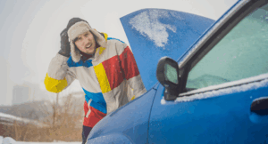 Mann vor Auto mit geöffneter Motorhaube – Auto springt bei Kälte nicht an